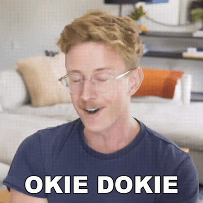 A Man Wearing Glasses And A Blue Shirt Says " Okie Dokie " In White Letters GIF