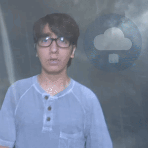 A Man Wearing Glasses And A Blue Shirt Stands In Front Of A Cloud GIF