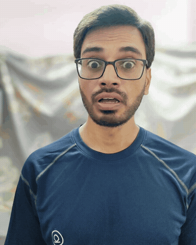 A Man Wearing Glasses And A Blue Shirt With An O On It GIF