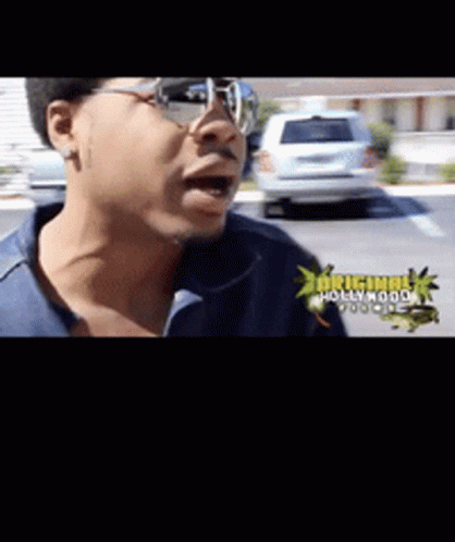 A Man Wearing Glasses And A Blue Shirt With The Words Original Hollywood On The Bottom GIF
