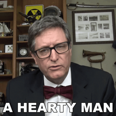 A Man Wearing Glasses And A Bow Tie Has The Words A Hearty Man Below Him GIF