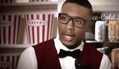 A Man Wearing Glasses And A Bow Tie Stands In Front Of A Cooler That Says Ce-Cold GIF