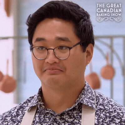 A Man Wearing Glasses And A Floral Shirt Is On A Tv Show Called The Great Canadian Baking Show GIF