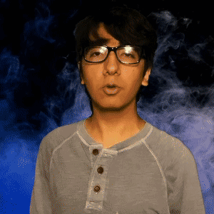 A Man Wearing Glasses And A Gray Shirt Is Standing In Front Of A Blue Background GIF
