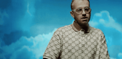 A Man Wearing Glasses And A Gucci Polo Shirt GIF