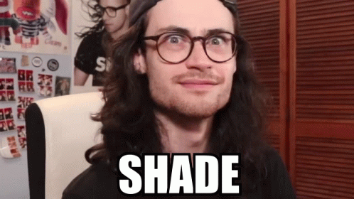 A Man Wearing Glasses And A Hat Has The Word Shade Written On His Face GIF