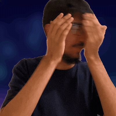 A Man Wearing Glasses And A Hat Is Covering His Face With His Hands GIF