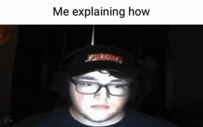 A Man Wearing Glasses And A Hat Is Explaining How He Is Playing A Game . GIF