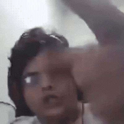 A Man Wearing Glasses And A Hat Is Pointing At The Camera . GIF
