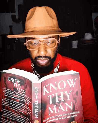 A Man Wearing Glasses And A Hat Is Reading A Book Titled Know Thy Man GIF