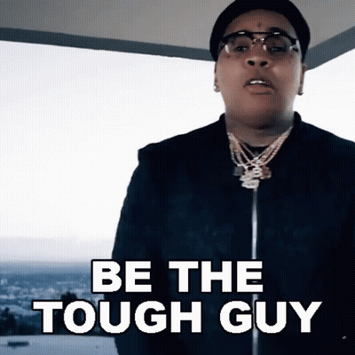 A Man Wearing Glasses And A Hat Is Saying Be The Tough Guy GIF