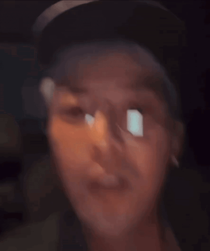 A Man Wearing Glasses And A Hat Looks At The Camera GIF