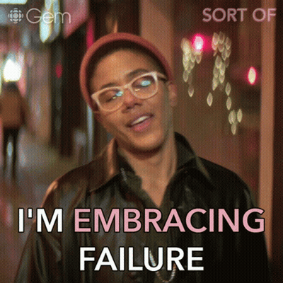 A Man Wearing Glasses And A Hat Says " I 'M Embracing Failure " In Pink Letters GIF