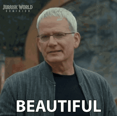 A Man Wearing Glasses And A Jacket Says Beautiful In A Jurassic World Dominion Advertisement GIF