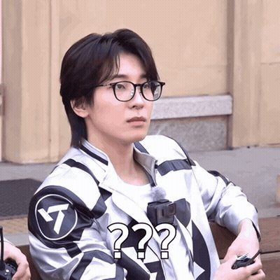 A Man Wearing Glasses And A Jacket With A Question Mark GIF