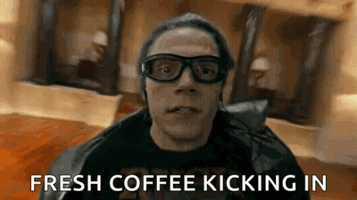 A Man Wearing Glasses And A Leather Jacket Is Holding A Cup Of Coffee . GIF