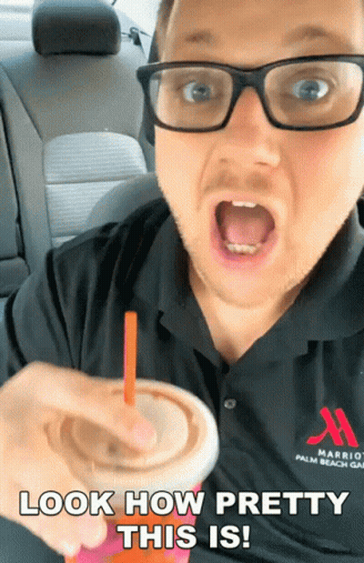 A Man Wearing Glasses And A Marriott Palm Beach Shirt Is Holding A Drink GIF