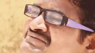 A Man Wearing Glasses And A Mustache Is Making A Face . GIF
