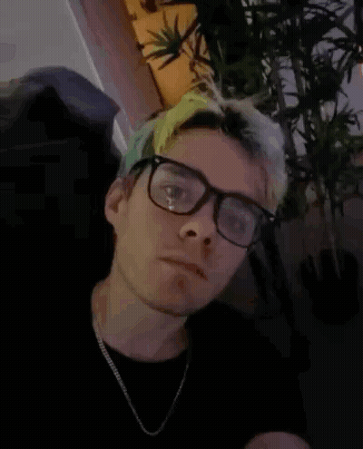 A Man Wearing Glasses And A Necklace Has The Words I Have A Bomb Written On His Face GIF