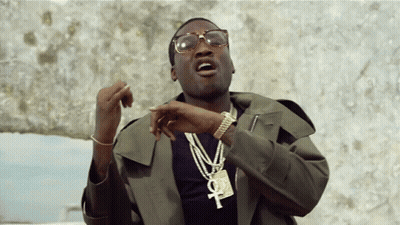 A Man Wearing Glasses And A Necklace With An Ankh Pendant GIF