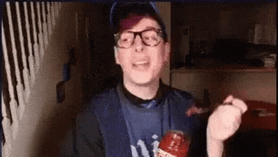 A Man Wearing Glasses And A Ny Yankees Shirt Is Holding A Bottle Of Ketchup In His Hand . GIF