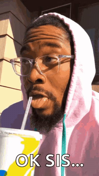 A Man Wearing Glasses And A Pink Hoodie Drinks Through A Straw And Says Ok Sis ... GIF