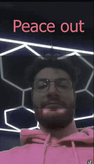 A Man Wearing Glasses And A Pink Hoodie With The Words Peace Out Written Above Him GIF