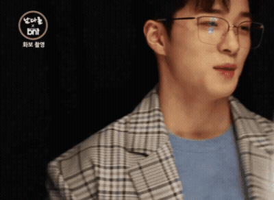 A Man Wearing Glasses And A Plaid Jacket With The Bnt Logo In The Corner GIF