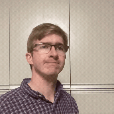 A Man Wearing Glasses And A Plaid Shirt Is Making A Face GIF