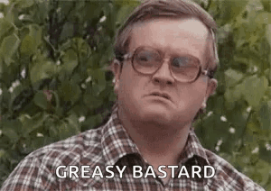 A Man Wearing Glasses And A Plaid Shirt Is Making A Funny Face And Saying `` Greasy Bastard '' . GIF