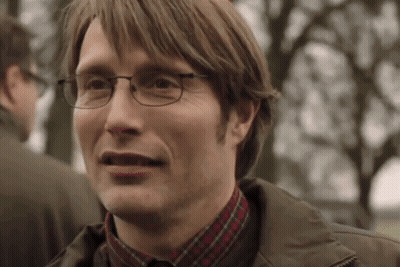 A Man Wearing Glasses And A Plaid Shirt Is Smiling And Making A Funny Face . GIF