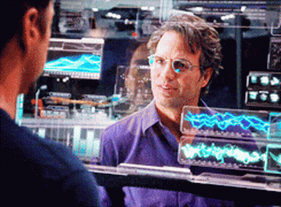 A Man Wearing Glasses And A Purple Shirt Is Looking At Another Man GIF