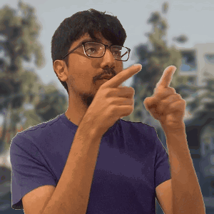 A Man Wearing Glasses And A Purple Shirt Is Pointing GIF
