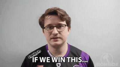 A Man Wearing Glasses And A Purple Shirt Is Standing In Front Of A White Wall . GIF