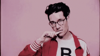 A Man Wearing Glasses And A Red Jacket Is Brushing His Teeth With A Toothbrush . GIF