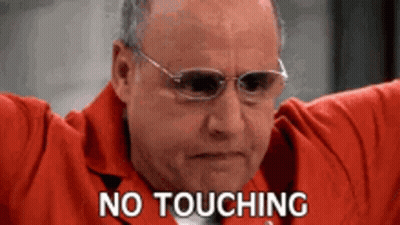 A Man Wearing Glasses And A Red Jacket Is Holding His Arms Out And Says `` No Touching '' . GIF