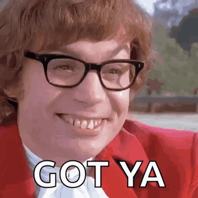 A Man Wearing Glasses And A Red Jacket Is Smiling And Saying Got Ya GIF