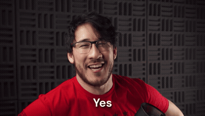 a man wearing glasses and a red shirt with the word yesssss on it