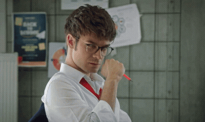 A Man Wearing Glasses And A Red Tie Holds A Pen GIF