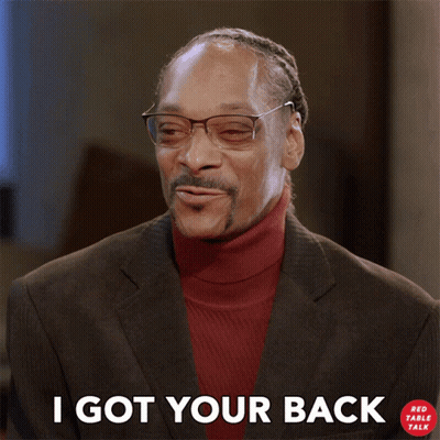 A Man Wearing Glasses And A Red Turtleneck Is Smiling And Says I Got Your Back GIF