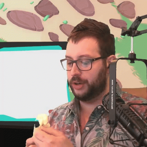 A Man Wearing Glasses And A Shirt That Says Abc On It Is Talking Into A Microphone GIF