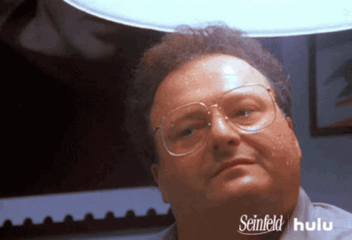 A Man Wearing Glasses And A Shirt That Says Seinfeld On The Bottom GIF