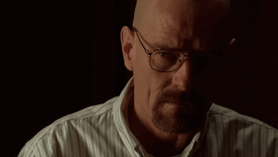 A Man Wearing Glasses And A Striped Shirt Looks At The Camera GIF