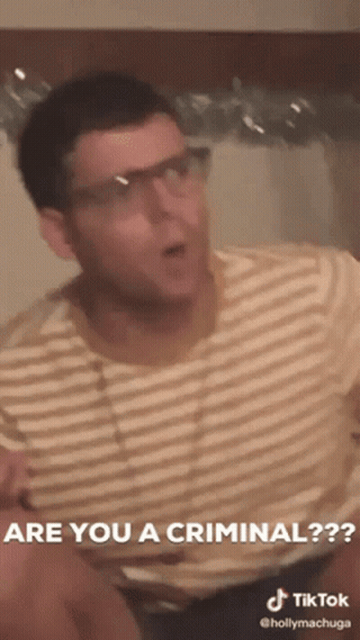 A Man Wearing Glasses And A Striped Shirt Says Are You A Criminal GIF