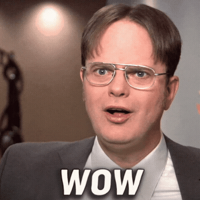 A Man Wearing Glasses And A Suit Has The Word Wow On His Chest GIF