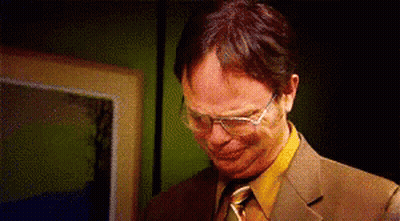 A Man Wearing Glasses And A Suit Is Making A Funny Face . GIF