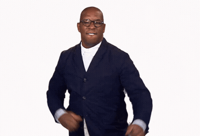 A Man Wearing Glasses And A Suit Is Running GIF