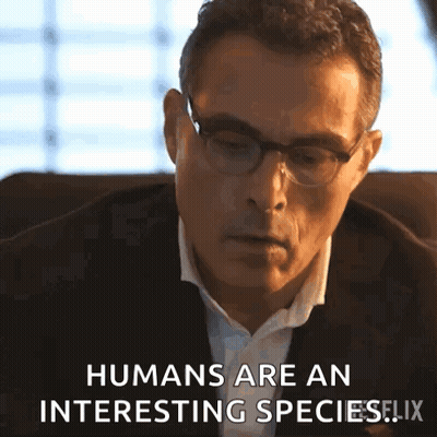 A Man Wearing Glasses And A Suit Is Sitting In A Chair And Says Humans Are An Interesting Species . GIF
