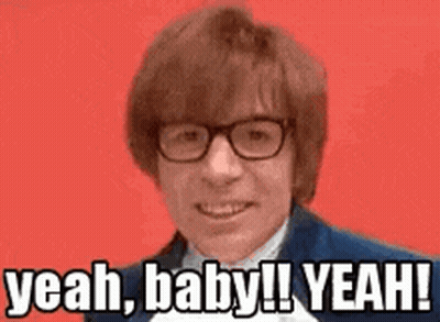A Man Wearing Glasses And A Suit Is Smiling And Saying `` Yeah , Baby ! Yeah ! '' GIF