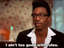 A Man Wearing Glasses And A Suit Is Talking About Rules . GIF